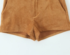 Detail of camel suede shorts featuring high-quality stitching and soft fabric texture