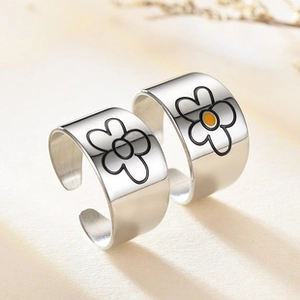 Macro shot of silver adjustable open rings with minimalist daisy pattern and metal gloss