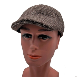 Close-up of classic brown checkered tweed fabric texture on a vintage flat cap