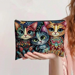 Détail d'une trousse à maquillage en toile avec trois motifs chats et fermeture éclair