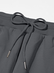Detail of dark grey jogger waistband with adjustable drawstring and metal tips