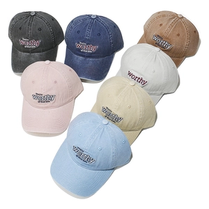 Detailed pile of washed cotton baseball caps showing embroidered text and multiple colors