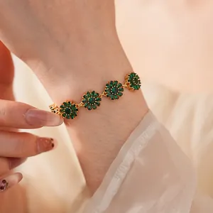 Close-up of gold-plated bracelet with four radiant emerald-green zircon flower motifs