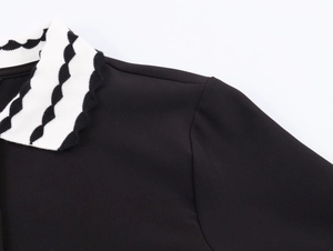 Detailed view of the black fabric polo neck with black and white wavy knit texture