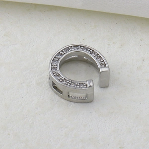 Close-up of silver C-shaped ear cuff with zircon micro-paving and hollow side detail