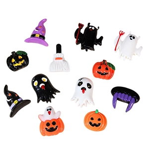 Assorted Halloween resin charms including pumpkins and ghost shapes on white background