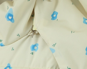 Macro detail of abstract floral print and premium metal zipper on beige winter jacket