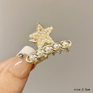 Detailed close-up of 2.5cm gold star hair claw clip with faux pearls and chain detail