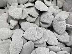 Macro view of textured grey exfoliating sponges showing soft porous surface detail