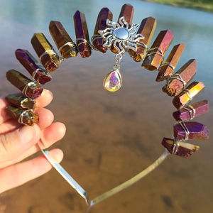 Detailed view of handmade gold crystal crown with sun pendant and teardrop gem