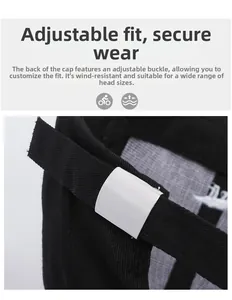 Close-up of adjustable metal buckle and strap on back of black cotton baseball cap