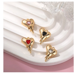 Close-up of molten lava heart pendants with colorful zircons on white ceramic tray