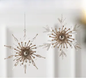 Detailed view of clear acrylic snowflakes with gold glitter and central gemstones