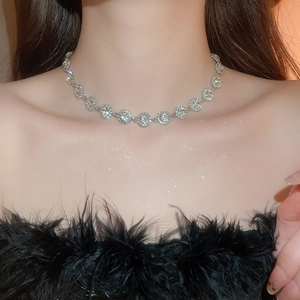 Dettaglio della collana in argento con diamanti scintillanti sul collo di una donna