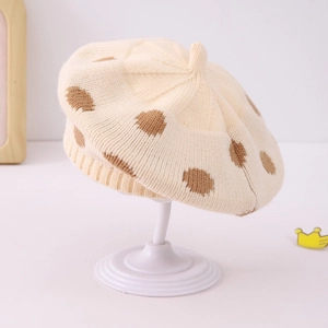 Detailed view of cream knitted beret with brown polka dots and soft ribbed edges