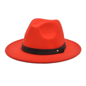 Detail of red wool felt fedora featuring a black belt band and gold stud accents