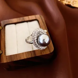 French luxury silver ring with grey pearl and pavé crystals on a silk background