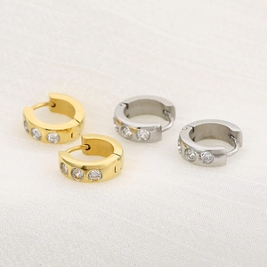 Dettaglio di orecchini a cerchio in titanio oro 18K e argento con tre pietre zirconi