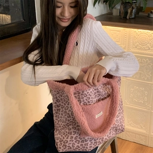Detail of pink leopard plush tote bag with soft fuzzy outer pocket and white woven label
