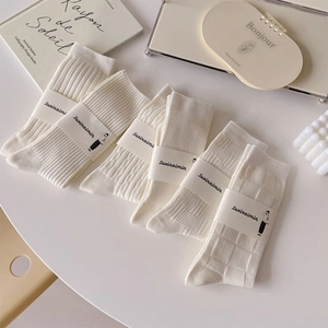 Set of 6 cream white crew socks with various knit patterns including ribbed and cable texture