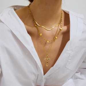 Three-layered 18K gold stainless steel necklaces with cross and heart charms on model