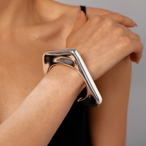 Close-up of polished silver geometric irregular triangle cuff bracelet on wrist