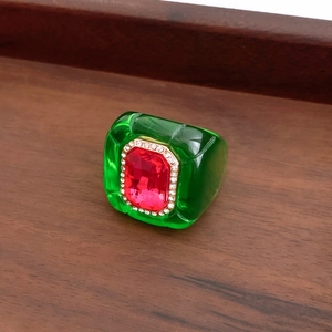 Macro view of vintage hexagonal resin ring with red center stone and crystal border