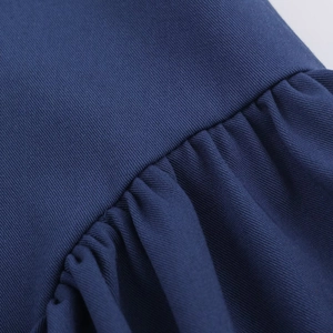 Gros plan sur le tissu bleu marine avec armure sergée et détails plissés délicats
