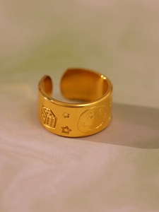 Macro shot of gold-plated ring showing detailed matte texture and engraved relief patterns