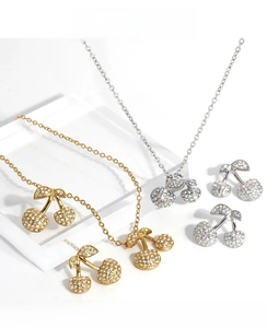 Close-up of sparkling zircon cherry jewelry sets in gold and silver finishes