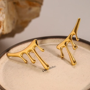 Poliert 18k Gold Edelstahl Ohrringe mit flüssigem Lava Design auf einem Keramikteller
