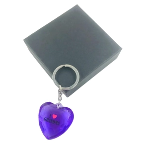 Purple heart acrylic keychain with I Love Grandma text next to a black gift box