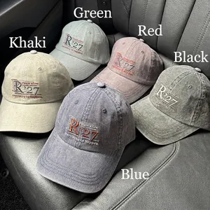 Five vintage washed cotton baseball caps with R'27 embroidery on leather car seat