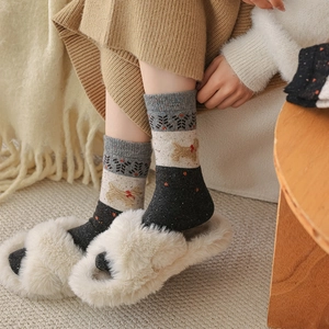 Close-up of thick wool socks with cute dog and snowflake patterns for winter warmth