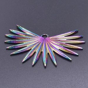 Macro shot of iridescent rainbow stainless steel wing charm with vacuum 18k gold plating