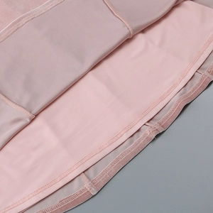 Detailed close-up of pink velvet dress hem showing fine stitching and smooth lining