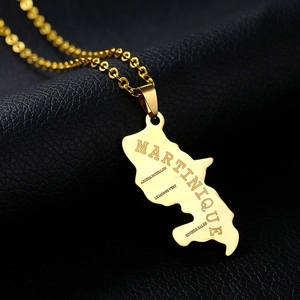 Macro shot of gold Martinique map necklace with detailed geographic engravings on black leather