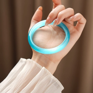 Detailed macro view of light blue cat-eye stone bangle showing fine fiber texture