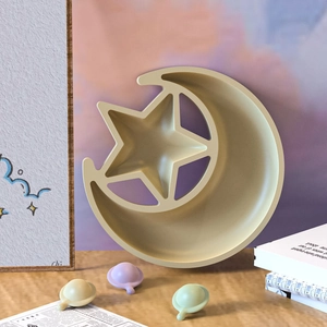 Star and moon silicone jewelry tray mold with three small planet accessories on wood desk