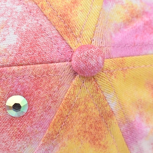 Macro detail of tie-dye baseball cap with colorful twill fabric and iridescent rhinestone