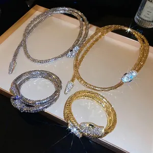 Luxury gold and silver snake jewelry set with sparkling rhinestones on champagne display