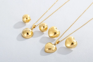 Detailed view of gold-plated heart and sphere jewelry set with polished metal finish