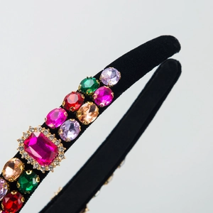 Detail of baroque velvet headband with colorful crystals and center ruby stone