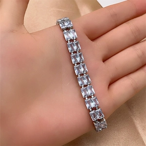 Detail of double-row rectangular zircon bracelet in silver claw setting on silk background