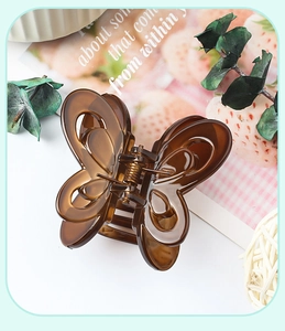 Detailed top view of a large translucent amber butterfly hair claw clip with cutout wings