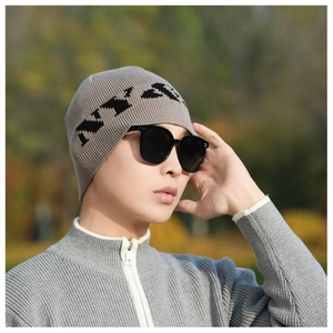 Detail of light gray knitted beanie with NYBE text showing soft warm texture