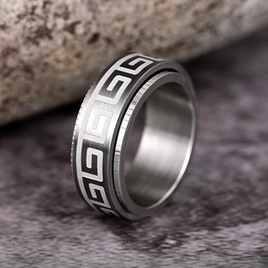 Macro detail of men's spinner ring with Greek meander pattern and silver brushed finish