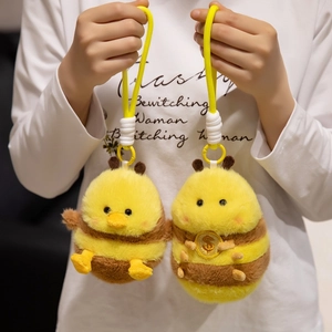 Cute plush bee duck keychain pendants with yellow woven straps held by hand