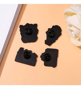 Detail view of cartoon frog pin backings featuring black rubber butterfly clutches