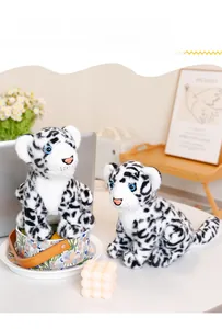 Detail of soft snow leopard plush toy set with blue eyes in a cozy home office setting